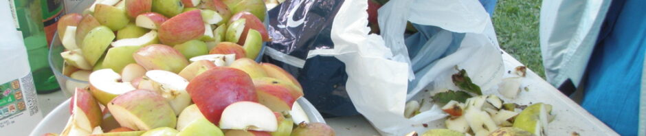 A table laden with chopped apples and a few empty bottles.