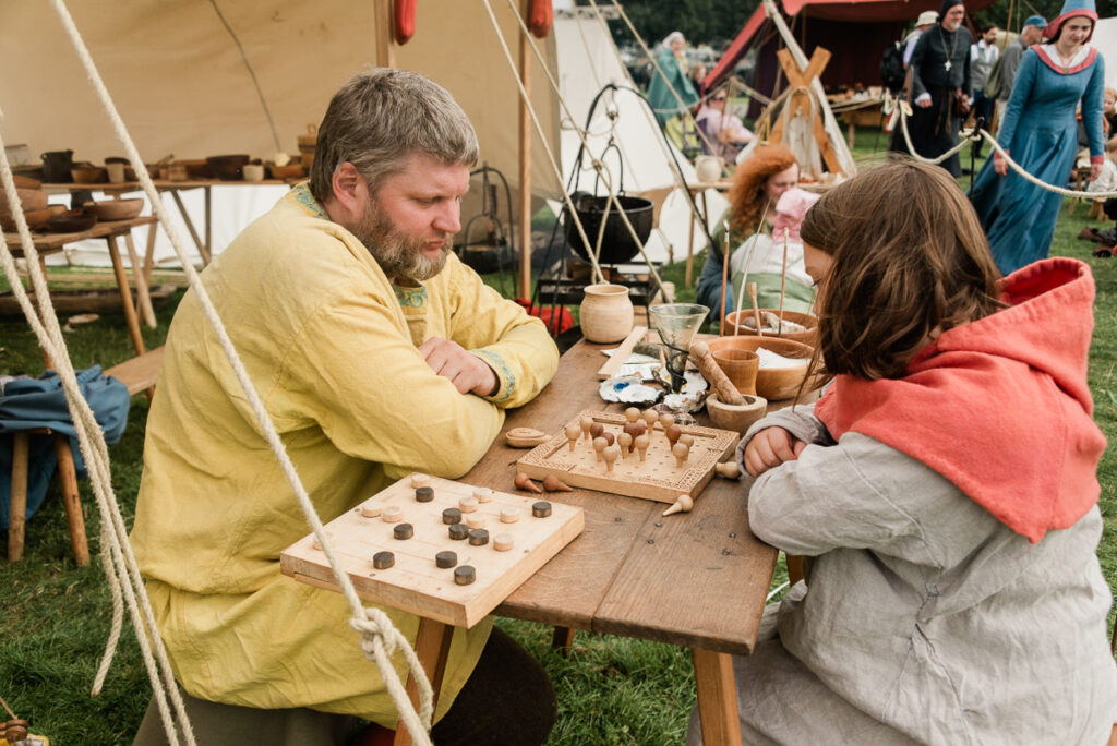 Two people re-creating Viking arts and crafts at a table